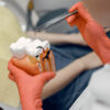 modello-di-un-dente-dal-dentista-il-medico-mostra-al-paziente-un-dente-ricezione-nell-ufficio-del-dentista-scaled.jpg